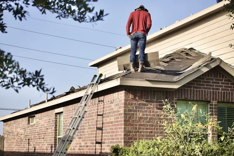 Professional roofer working on a residential roof in Comus